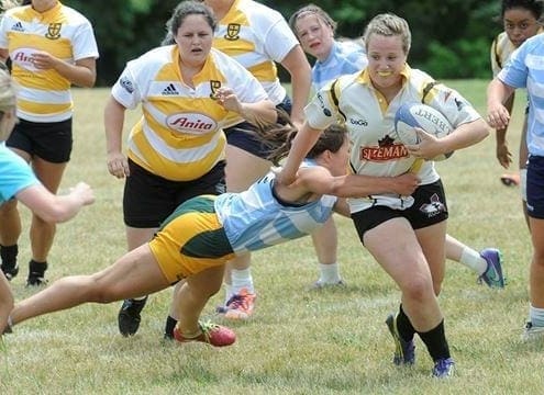 Crusaders Rugby Club players in yellow and white jerseys battle for the ball on a grassy field in Oakville.