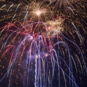 Multicolored fireworks bursting in a dark night sky.