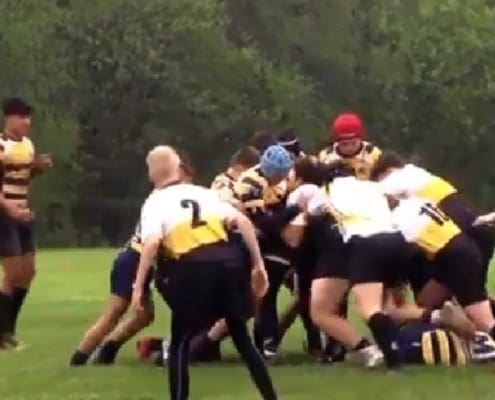Rugby players from the Crusaders Rugby Club in Oakville engage in a scrum on a grassy field.