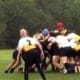 Rugby players from the Crusaders Rugby Club in Oakville engage in a scrum on a grassy field.
