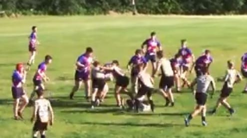 Rugby players from the Crusaders Rugby Club in Oakville contest a ruck on a grassy field.