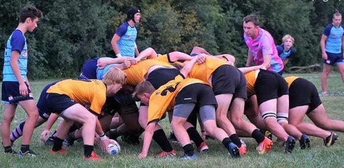 Crusaders Rugby Club players in Oakville contest a scrum on a grassy field.
