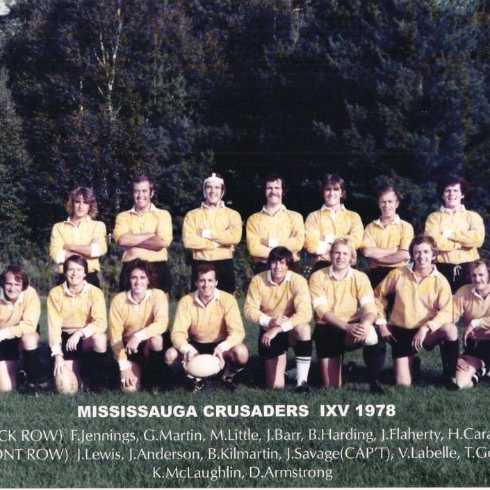 Vintage team photo of a rugby club in yellow jerseys posing in two rows on a grassy field.