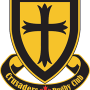 Crusaders Rugby Club emblem from Oakville: a gold shield with a black border and central black cross, with a curved black banner below reading “Crusaders Rugby Club” and a red maple leaf.