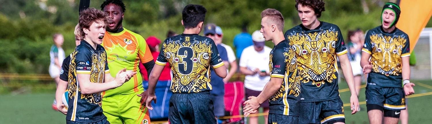 Crusaders Rugby Club players from Oakville pose on a rugby field in navy and gold uniforms. Crusaders Rugby Club players from Oakville pose on a rugby field in navy and gold uniforms.