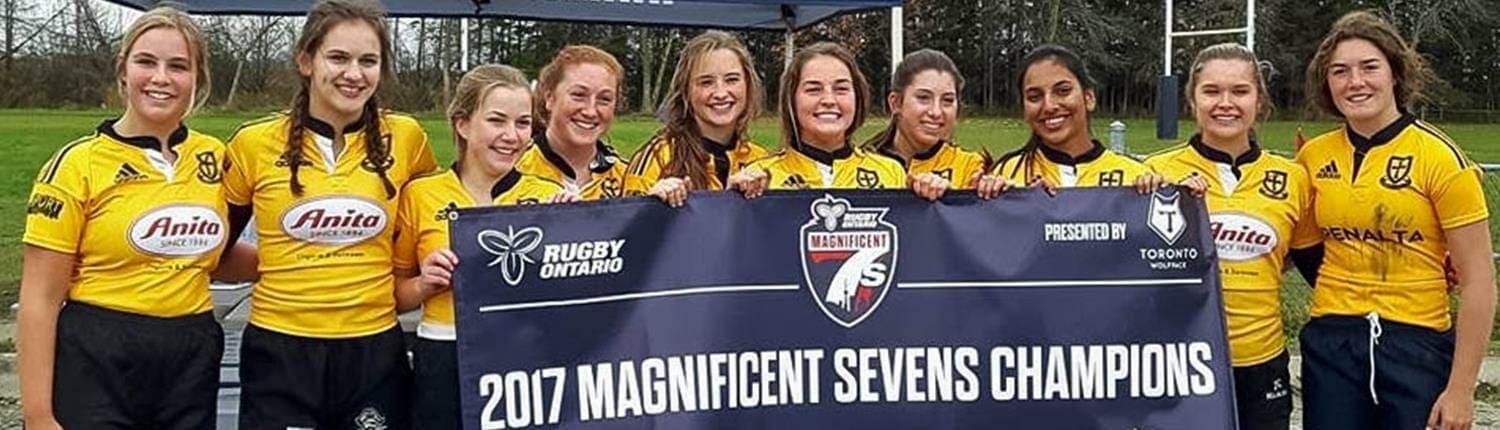 Group of Crusaders Rugby Club of Oakville players in yellow jerseys posing with a banner that reads 2017 Magnificent Sevens Champions. Group of Crusaders Rugby Club of Oakville players in yellow jerseys posing with a banner that reads 2017 Magnificent Sevens Champions.