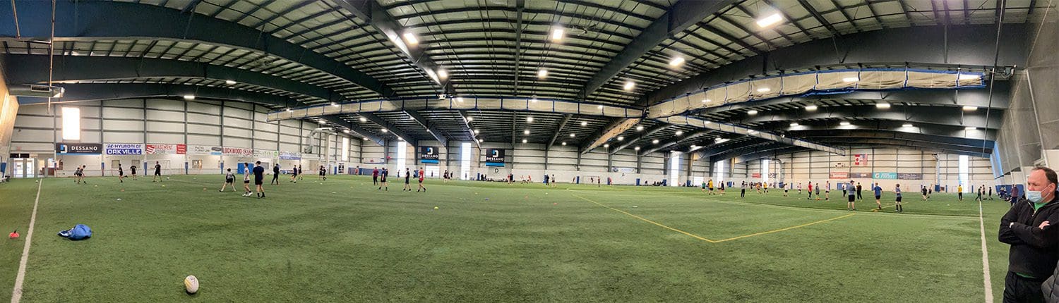 Indoor field in Oakville with players practicing on artificial turf.