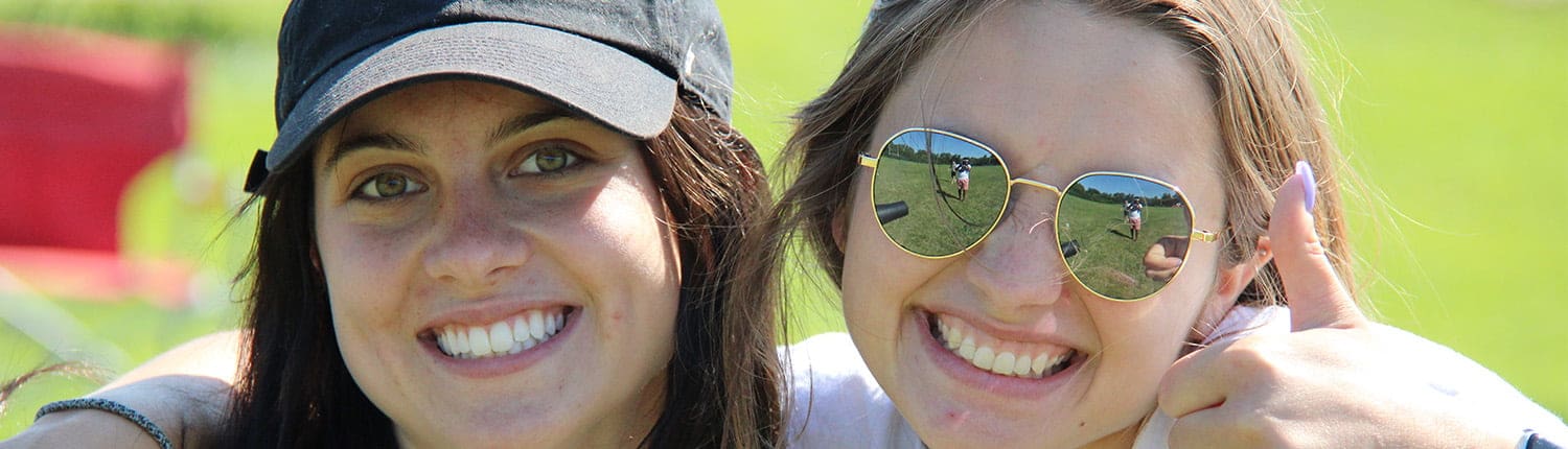Two smiling women on a rugby field representing the Crusaders Rugby Club in Oakville. Two smiling women on a rugby field representing the Crusaders Rugby Club in Oakville.
