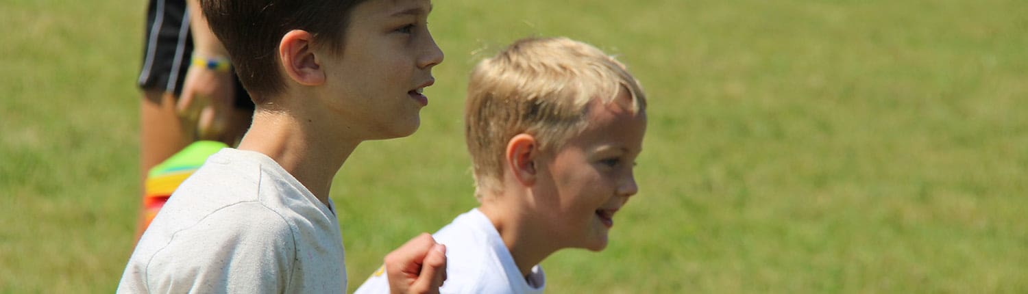 Two young Crusaders Rugby Club players stand on a grassy field in Oakville. Two young Crusaders Rugby Club players stand on a grassy field in Oakville.