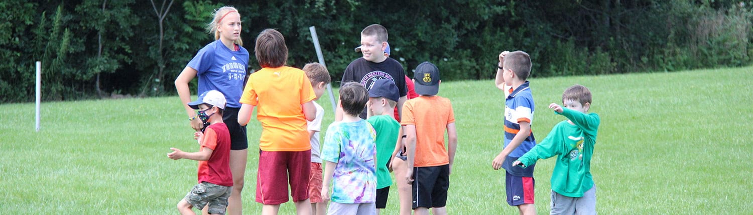Young rugby players in colorful jerseys listen to a coach during practice on a grassy field at Crusaders Rugby Club in Oakville. Young rugby players in colorful jerseys listen to a coach during practice on a grassy field at Crusaders Rugby Club in Oakville.