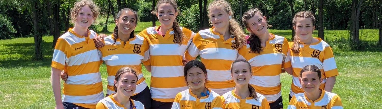 Crusaders Rugby Club players in yellow-and-white striped jerseys pose for a team photo on a grassy field in Oakville.