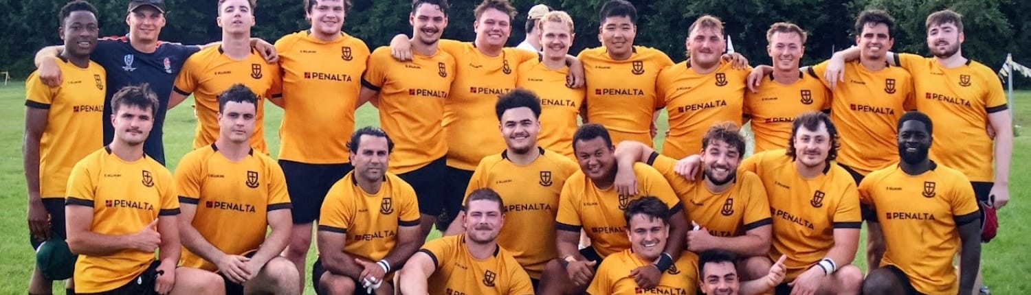 Senior Men A group of twenty three men, most wearing yellow and black sports jerseys emblazoned with PENALTA, are posing for a photograph on a grassy field.