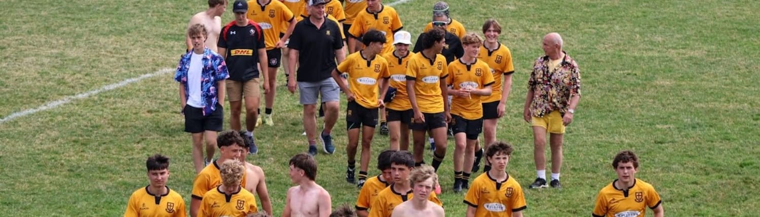 U16 Boys Group of Crusaders Rugby Club players in yellow jerseys standing on a grassy rugby field in Oakville.